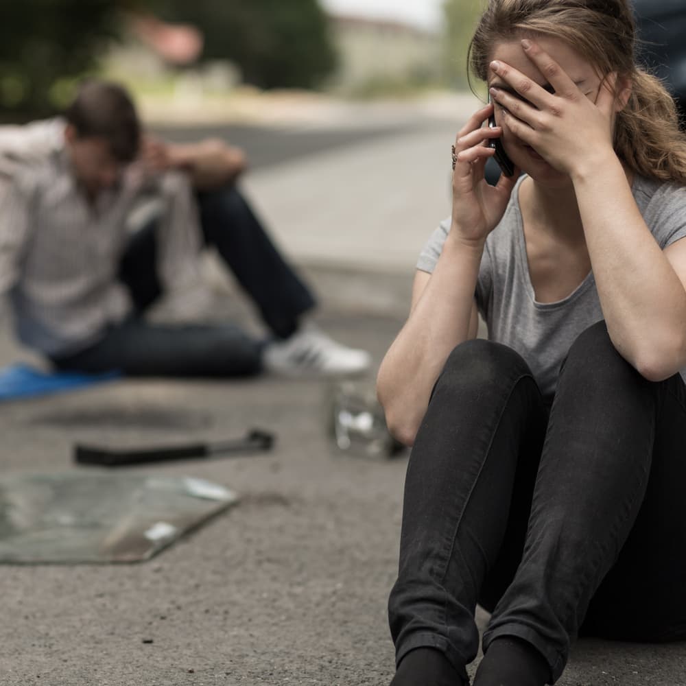 Young female driver in despair after a traffic accident.