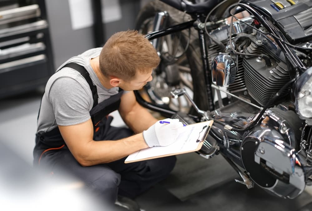 The man checks the motorcycle and determines the fault after an accident.






