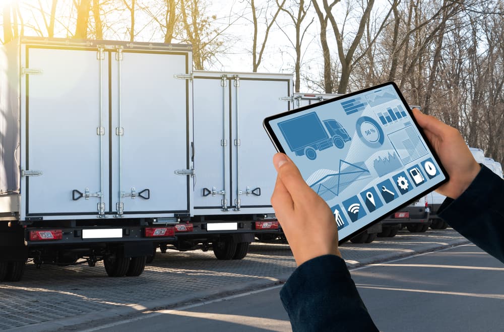 Insurance Agent with a Digital Tablet Standing Behind Trucks






