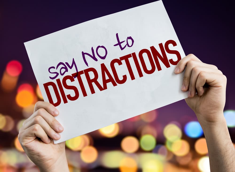 "Say No to Distractions" placard with night lights in the background.