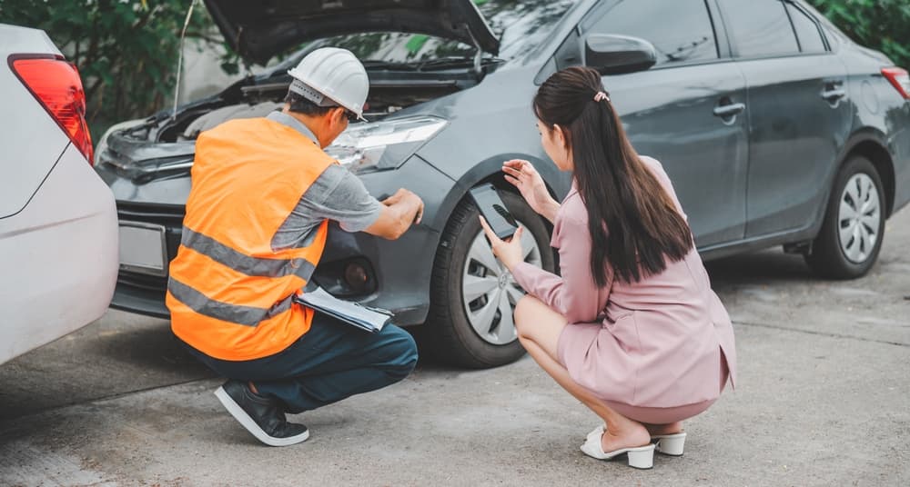 A male insurance officer arrives to inspect a customer's car after an accident. Concept for vehicle collision and insurance claim assistance.







