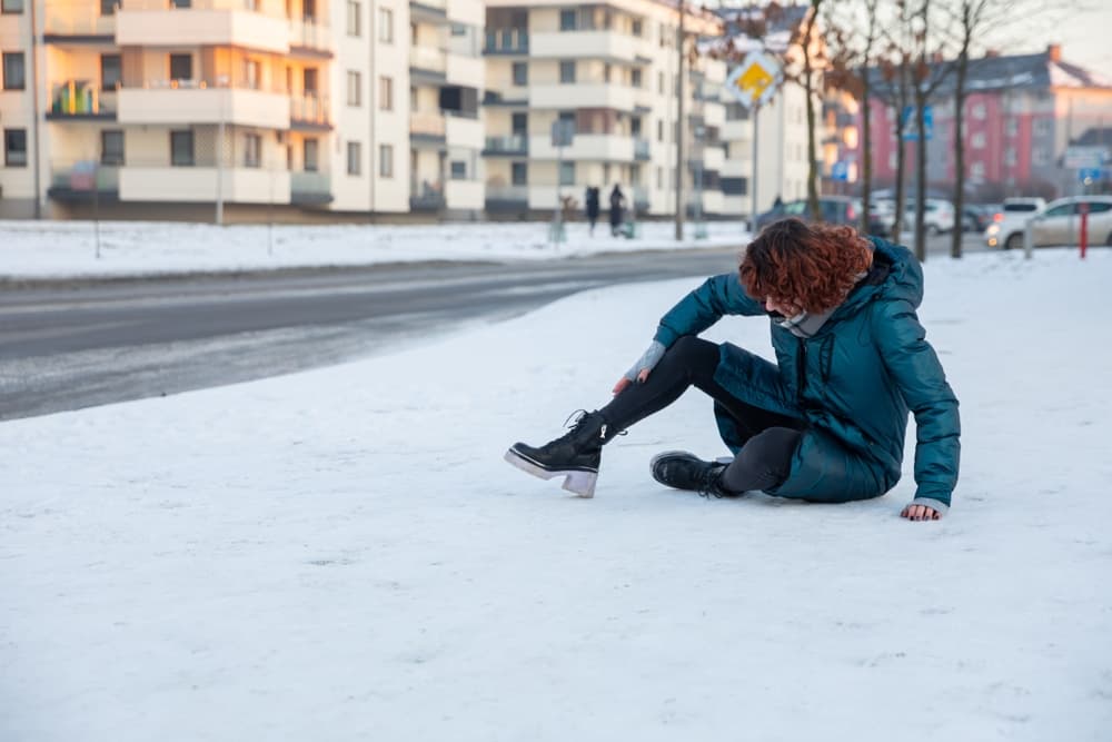 The girl slipped on the icy sidewalk while walking