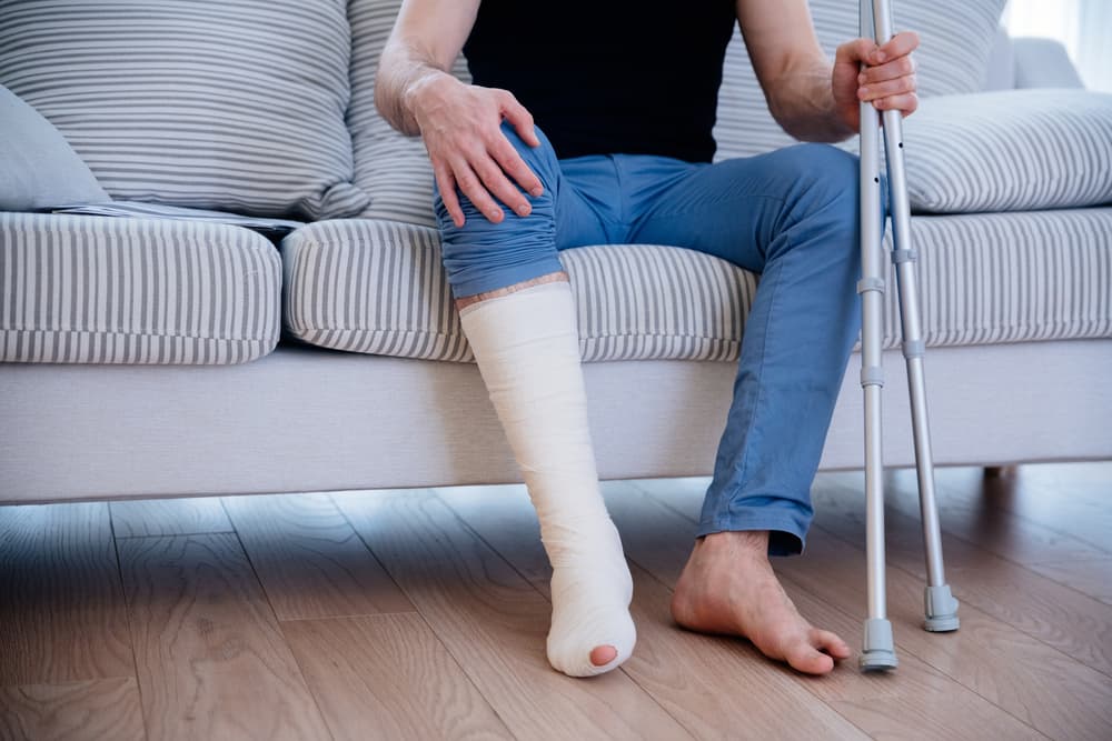 Man with broken leg at home. 