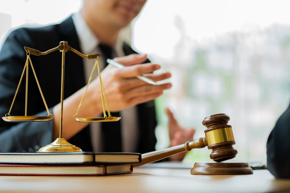 Lawyer providing legal services at the desk with scales of justice and gavel, symbolizing labor law advice at the legal office.