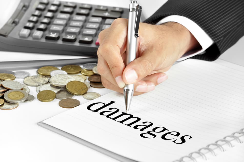 car accident lawyer calculating damages in accident with coins on the table