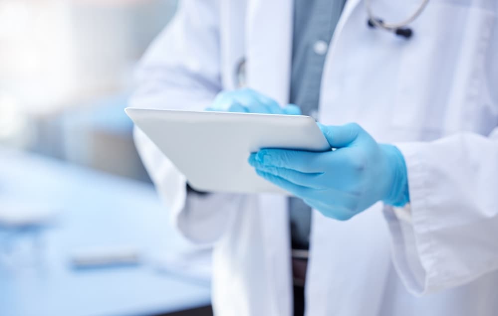 Doctor, hands and gloves with digital tablet for record keeping of patient in hospital with consulting.