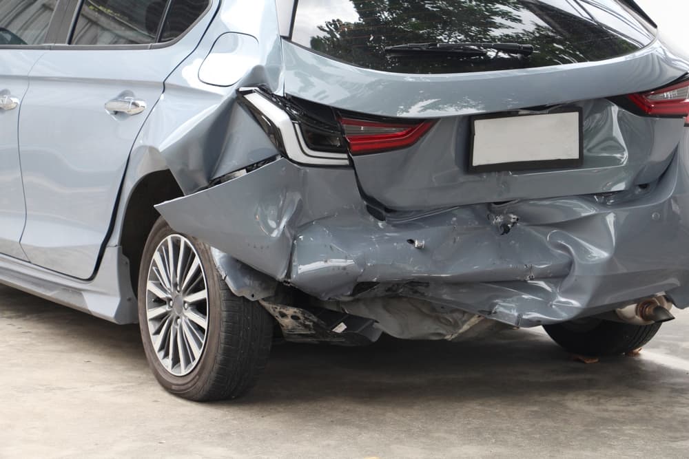 Close up view with The rear of Hatchback type Car wreck in the parking with broken parts. crash big damaged and broken car. 