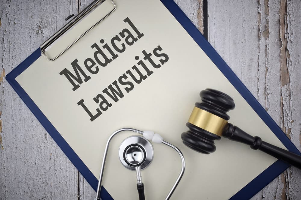 Medical Lawsuits wording with Gavel and stethoscope on a paper file.